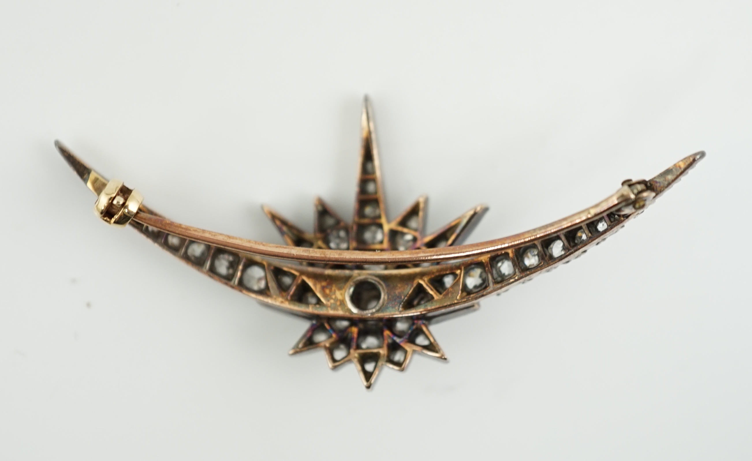 A Victorian gold, silver and graduated diamond cluster set crescent and starburst brooch